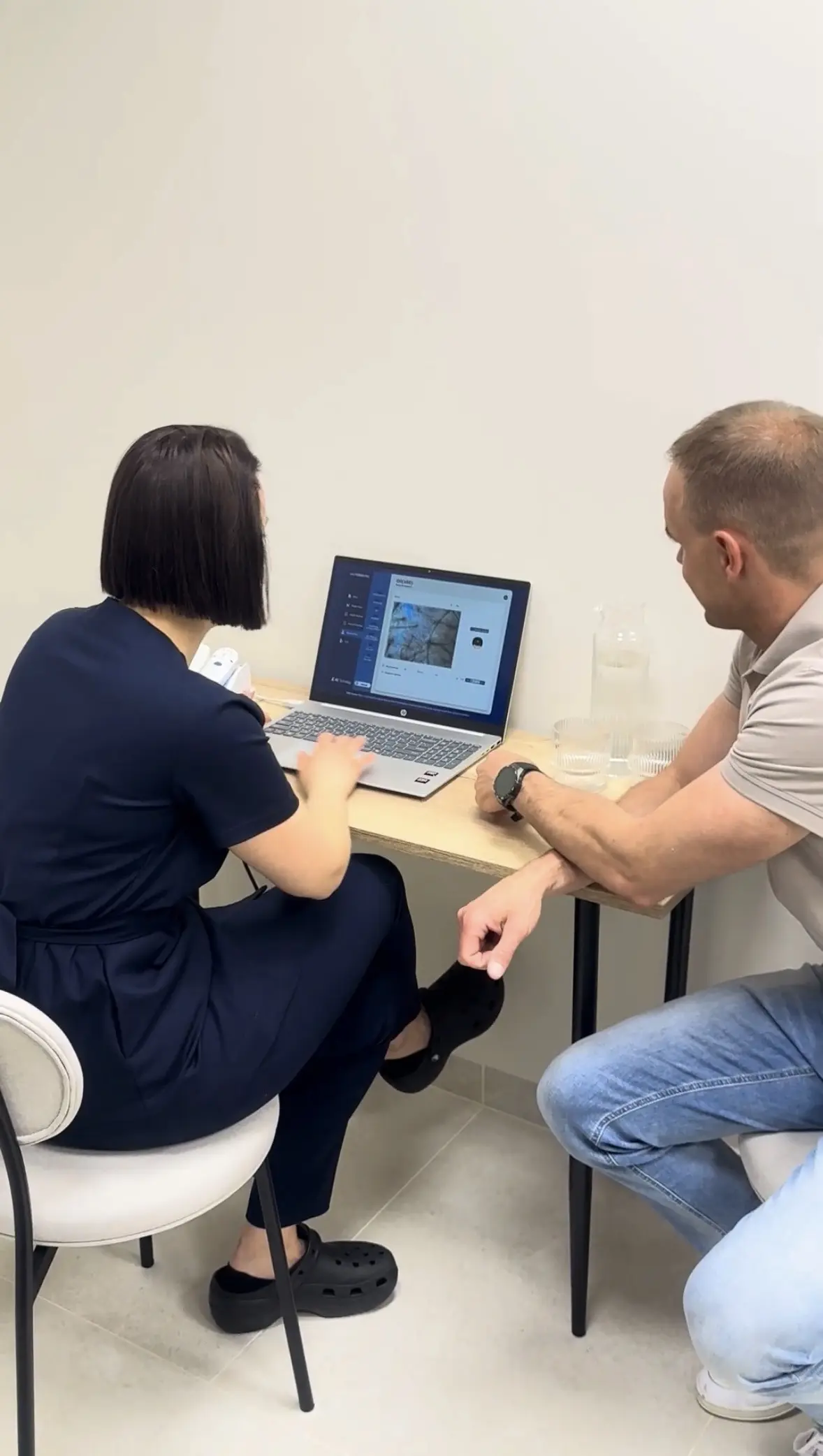 Trichoskopia: trycholog i pacjent oglądają obraz skóry głowy na ekranie laptopa